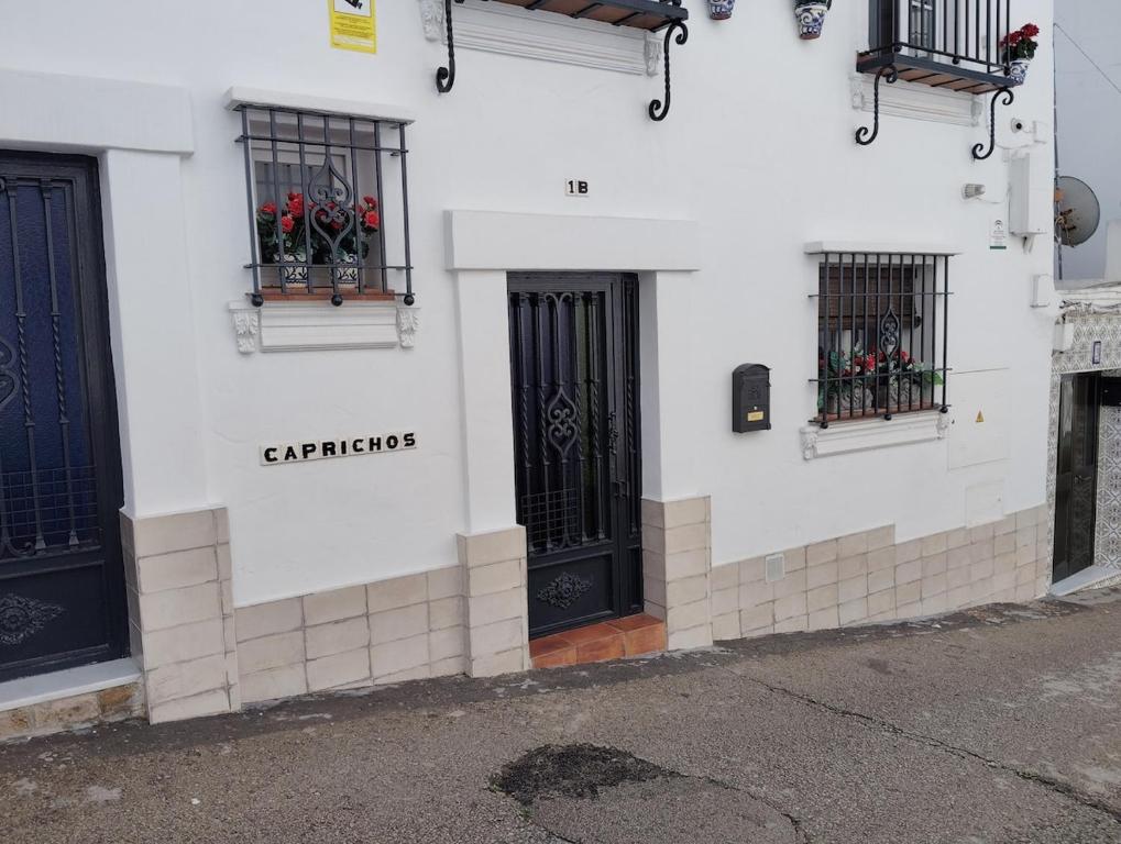 a white building with black doors and windows at Capricho Azul in Conil de la Frontera