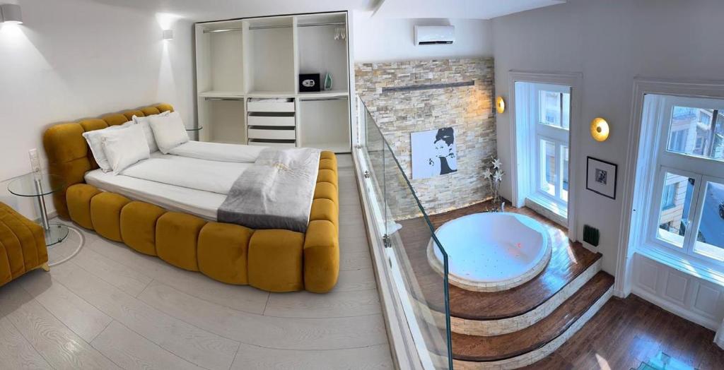 a living room with a yellow couch and a fireplace at Enzo Capo Jacuzzi Andrassy in Budapest