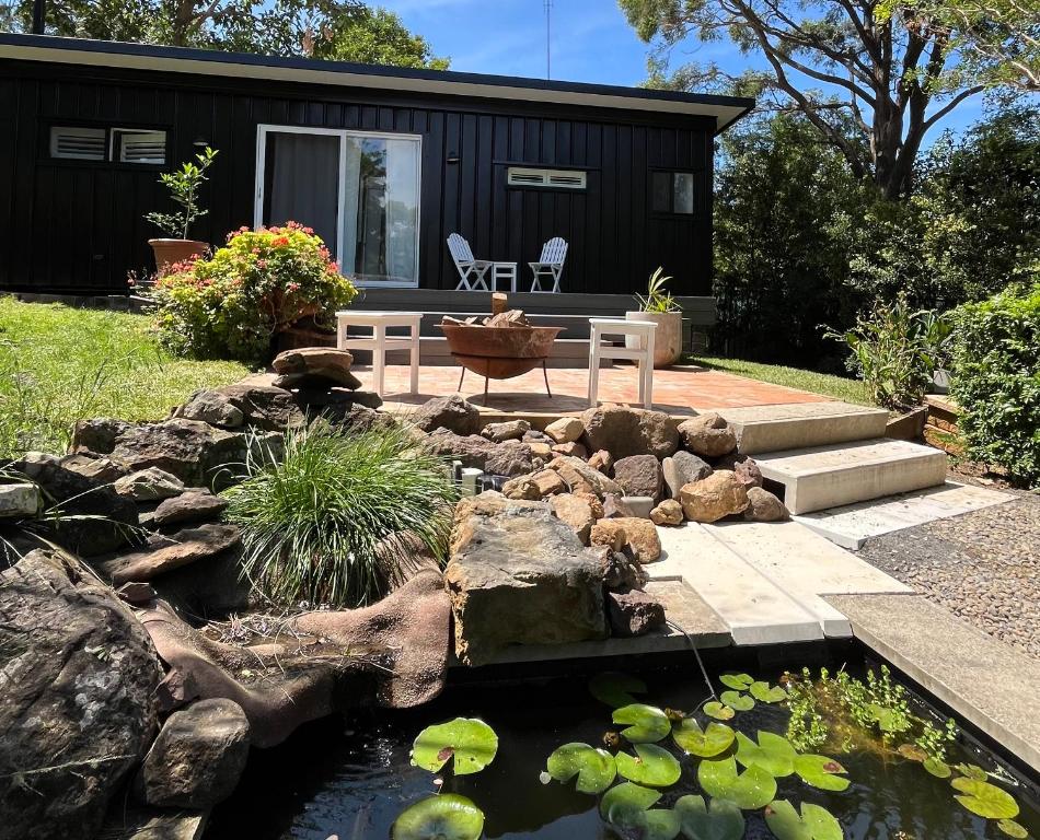 a backyard with a pond and a tiny house at Wollongong Tiny Home in Coniston