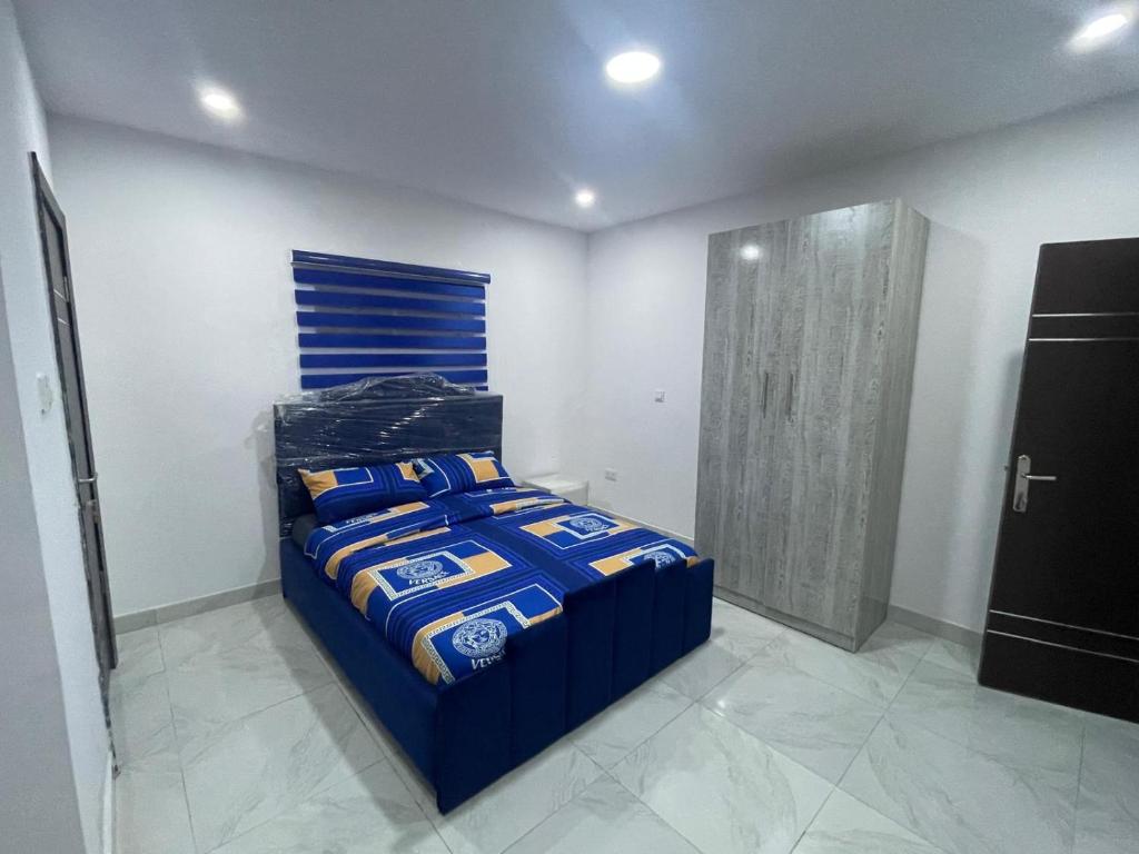 Un dormitorio con una cama con un edredón azul. en Trinity Apartments, en Lekki