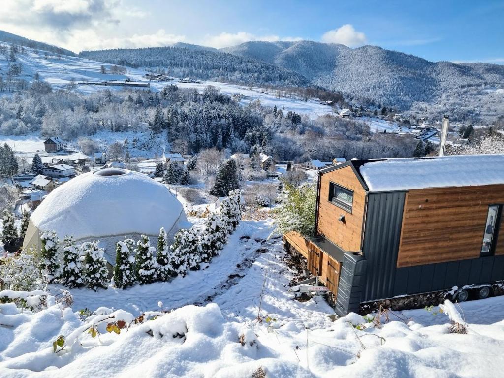 une minuscule maison dans la neige avec une yourte dans l'établissement Tiny House, Hautes Vosges, à Saint-Maurice-sur-Moselle