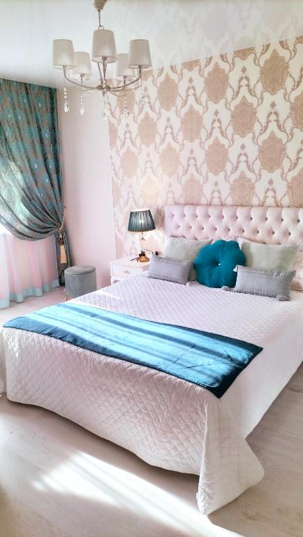a bedroom with a large white bed with blue sheets at Тіффані Апартаменти in Dnipro