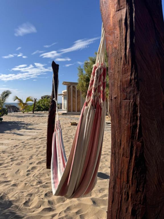 a hammock hanging from a pole on the beach at Ribera Del Norte Bungalows in Canoas