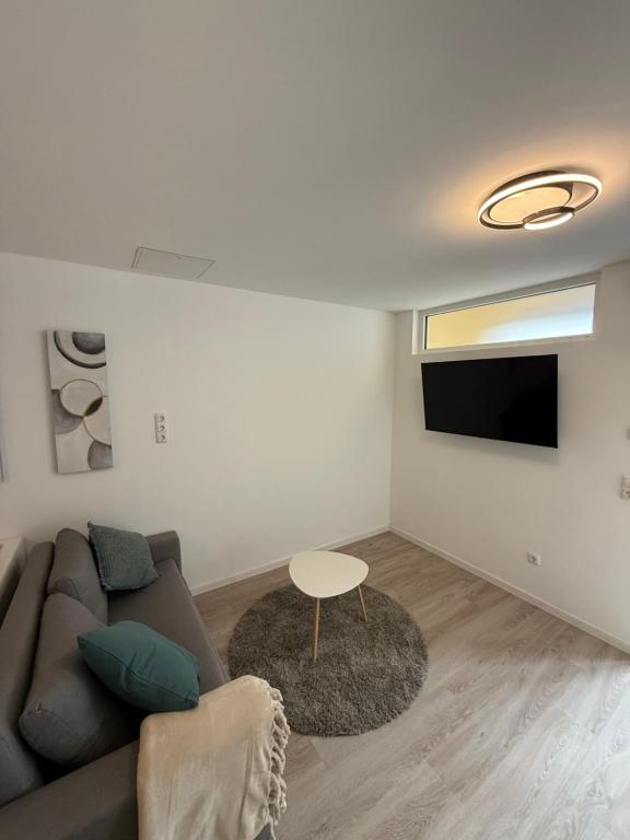 Smart Home Bad Camberg - moderne Ferienwohnung في باد كامبيرغ: غرفة معيشة مع أريكة وتلفزيون