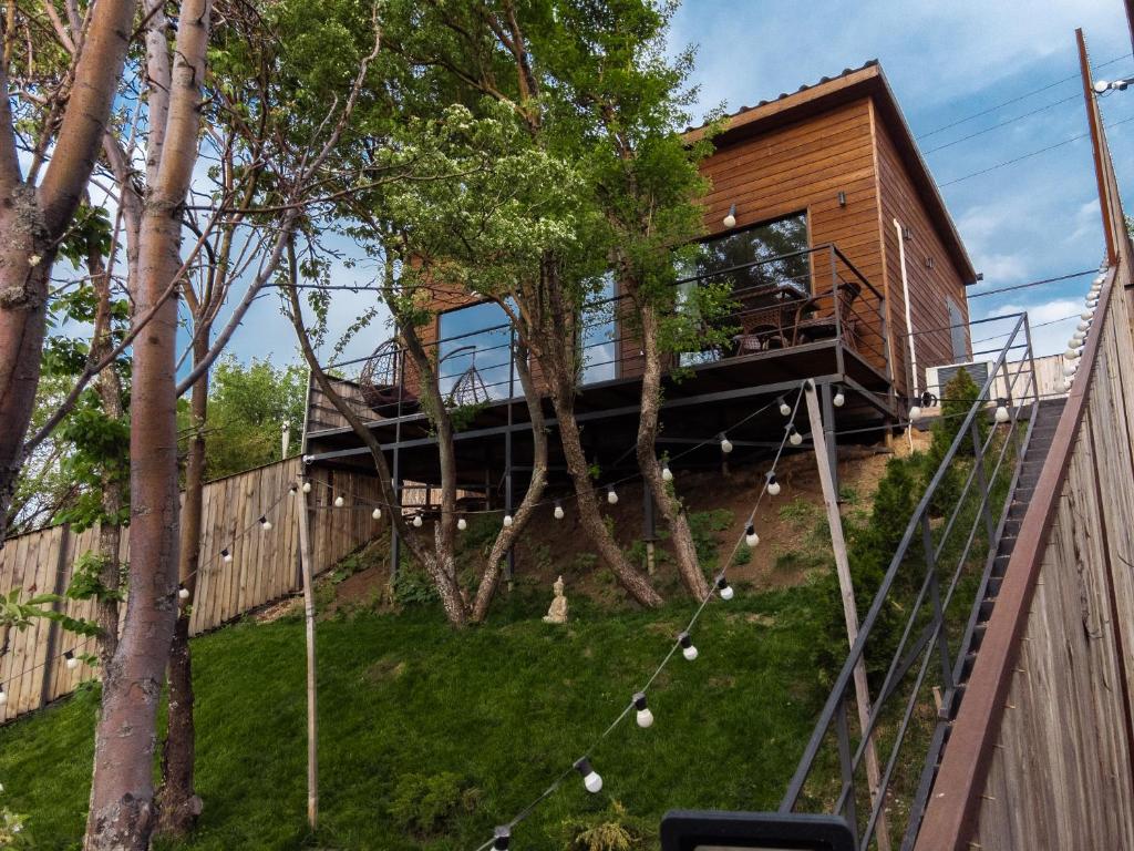 a house on the side of a hill with trees at Secluded Cabins with Mountain & Sunset Views in Almaty