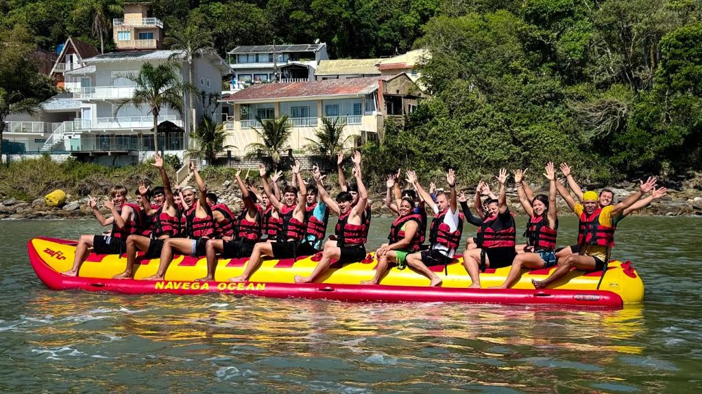a group of people sitting on a raft in the water at NAVEGA BEACH HOUSE - Casa 2 Andares - Rede Navega Hotéis in Navegantes