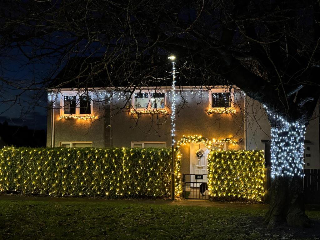 Uma casa com luzes de Natal à frente. em Edinburgh Home from Home em EDI