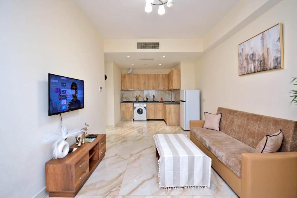 a living room with a couch and a tv at Your Yerevan Home in Yerevan
