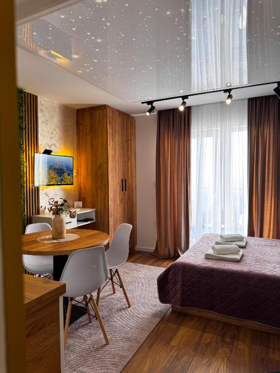 a bedroom with a bed and a table and chairs at MunSpell Apartment in Kopaonik