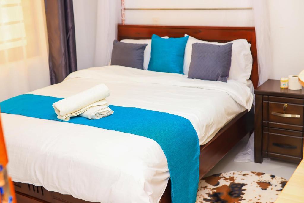 基苏木Mina Homes的一间卧室配有两张带蓝白色床单的床