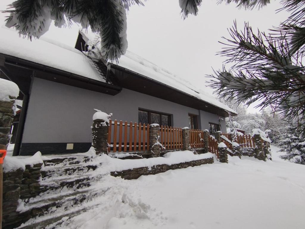 une maison enneigée avec une cour enneigée dans l'établissement Chatka Puchatka, à Tenczyn