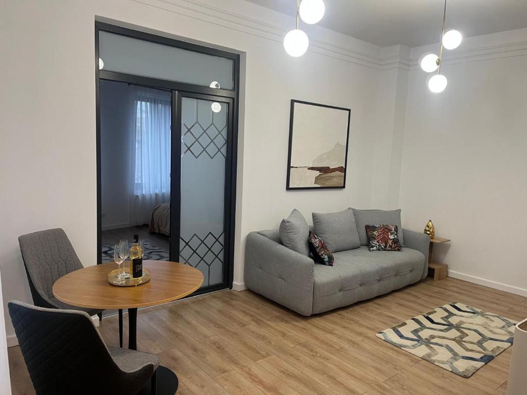 ein Wohnzimmer mit Sofa und Tisch in der Unterkunft ARIS ULTRACENTRAL APARTAMENT 2 camere PIATA UNIRII in Iaşi