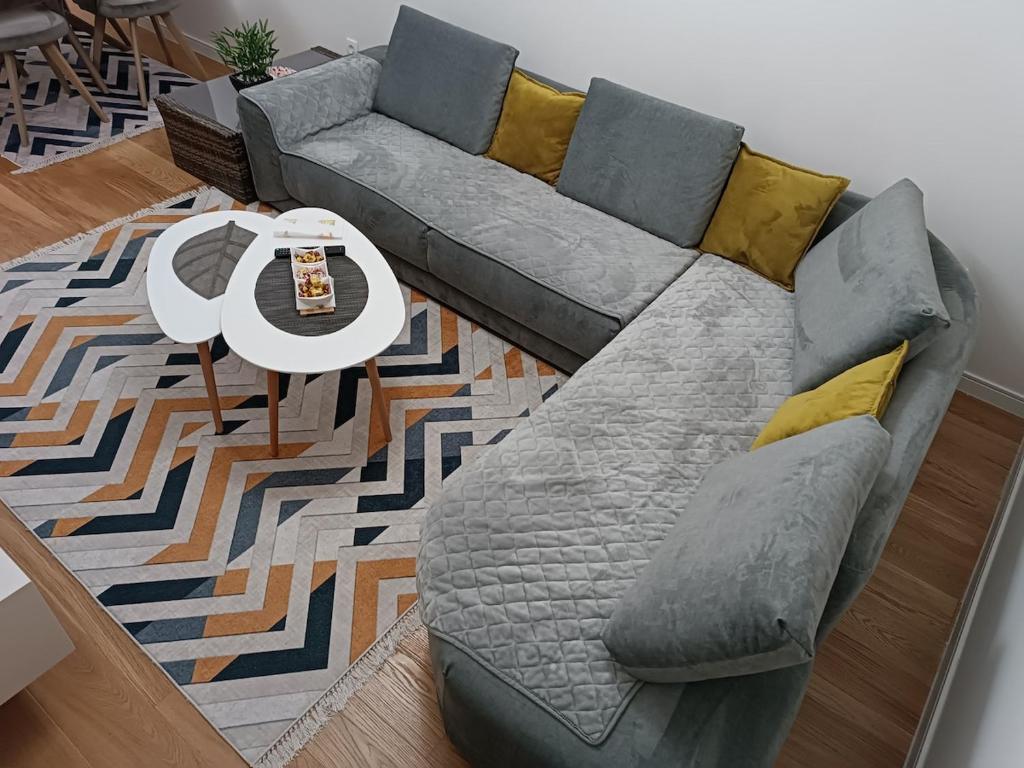 een grijze bank in een woonkamer met een tafel bij Gorgerous 2 Bed Apartment in Bar