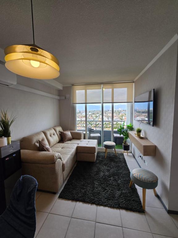 ein Wohnzimmer mit Sofa und Fernseher in der Unterkunft Departamento Céntrico 2 o 3 dorm con Parckin Piscina y Wifi in Rancagua