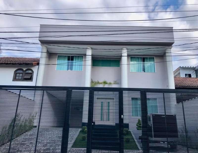 una casa blanca con una valla delante en Pousada Lima, en Volta Redonda