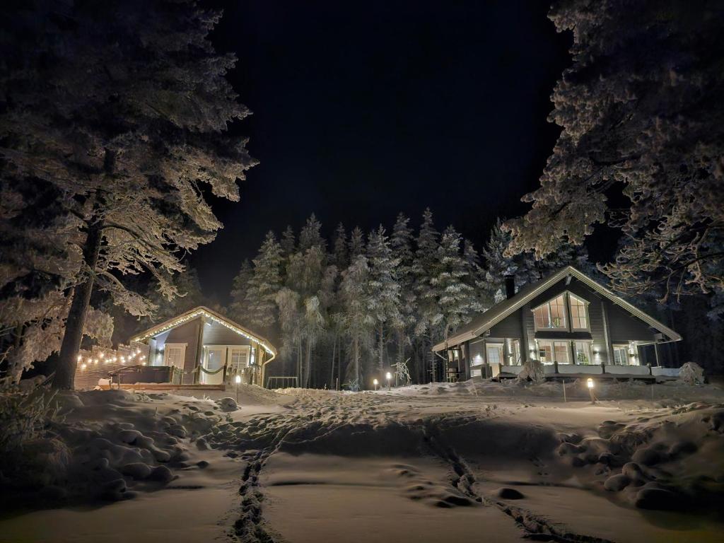 ein Haus ist nachts mit Schnee bedeckt in der Unterkunft Villa Huilinki in Ranua