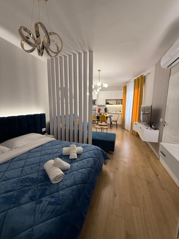 a bedroom with a blue bed with towels on it at Juar Villa - Modern Apartments in Tirana