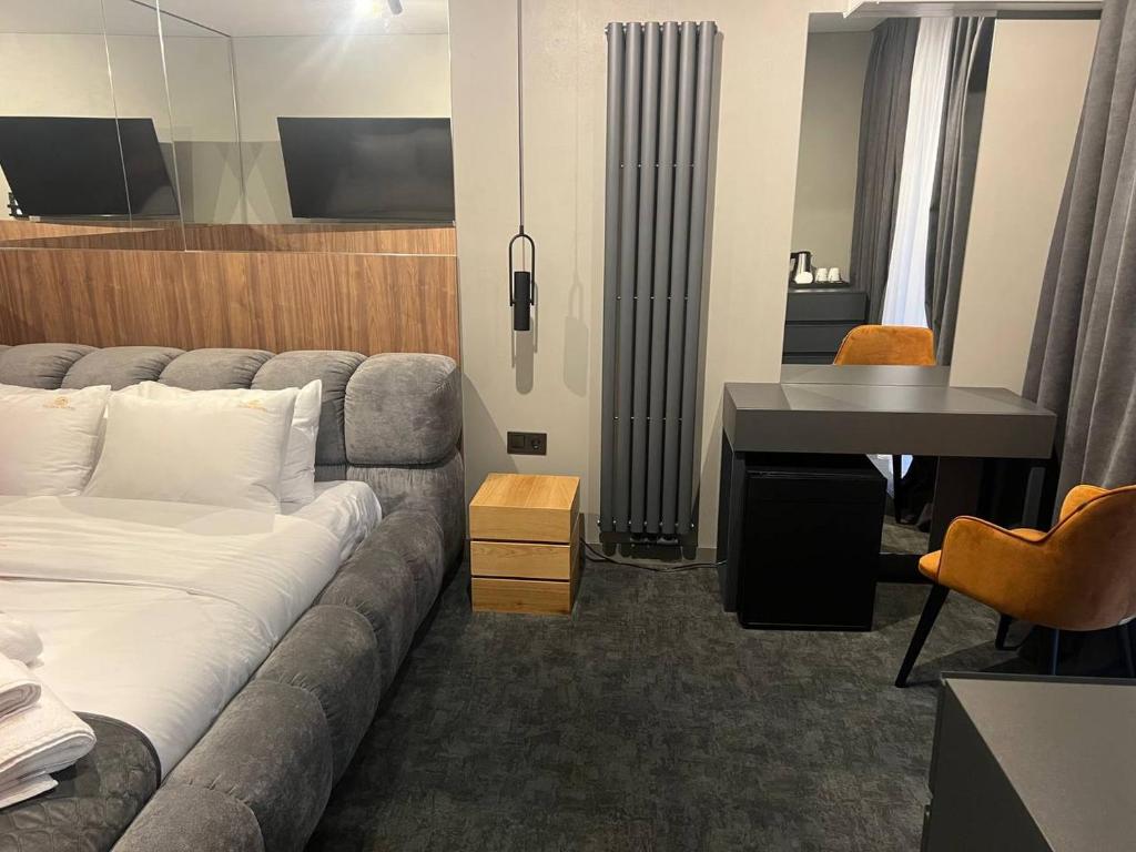 Una sala de estar con un sofá y un escritorio en una habitación. en Gloria Hotel by YOLO, en Szack