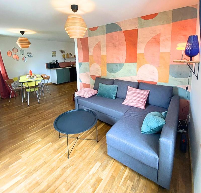 a living room with a blue couch and a table at Vinyle club-rétro 70's-6 pers-Terrasse-Wifi-Parking in Bellême