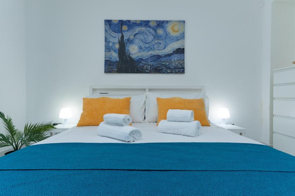 Promo Natale, Esclusiva Struttura Fronte Mare, Vicino al Centro Città في بيسكارا: غرفة نوم مع سرير أزرق كبير مع وسائد برتقالية