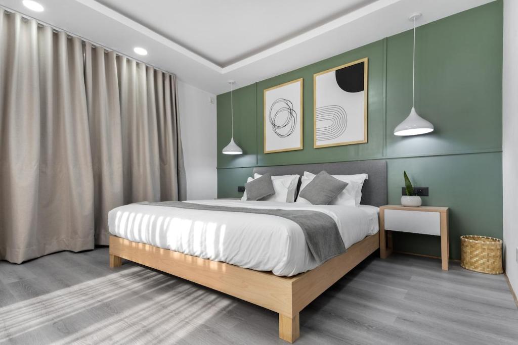 1 dormitorio con 1 cama grande y paredes verdes en Cosy 1 Bedroom Studio with King Bed Kitchenet in Central Kathmandu with Terrace, en Katmandú