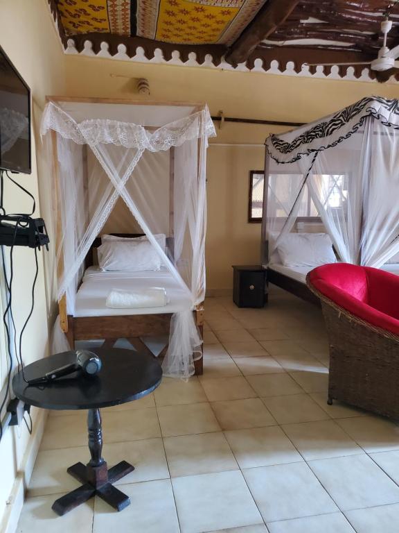 Zimmer mit 2 Etagenbetten und einem Stuhl in der Unterkunft Kivuli Holiday Homes Limited in Galu