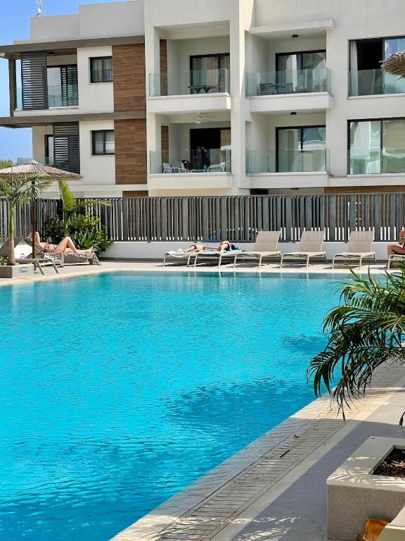 a swimming pool in front of a building at Fall In Paradise in Paralimni
