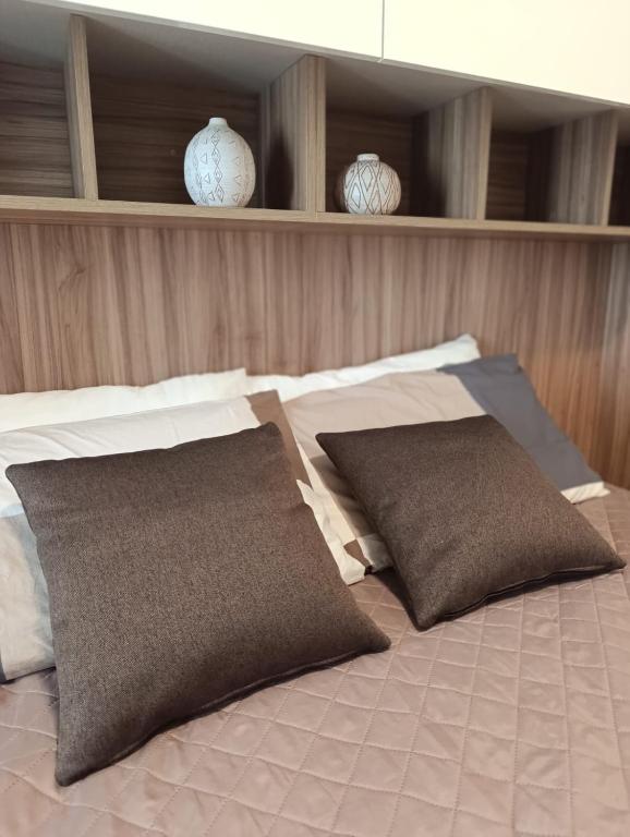 a bed with two pillows on top of it at Residenza dentro le mura - 5 min walk to Bernina Express in Tirano