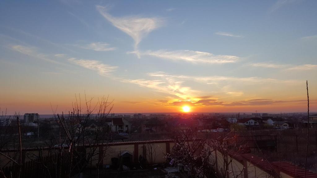 克拉约瓦Harmony Villa Craiova的太阳高悬在天空，城市上空的日落