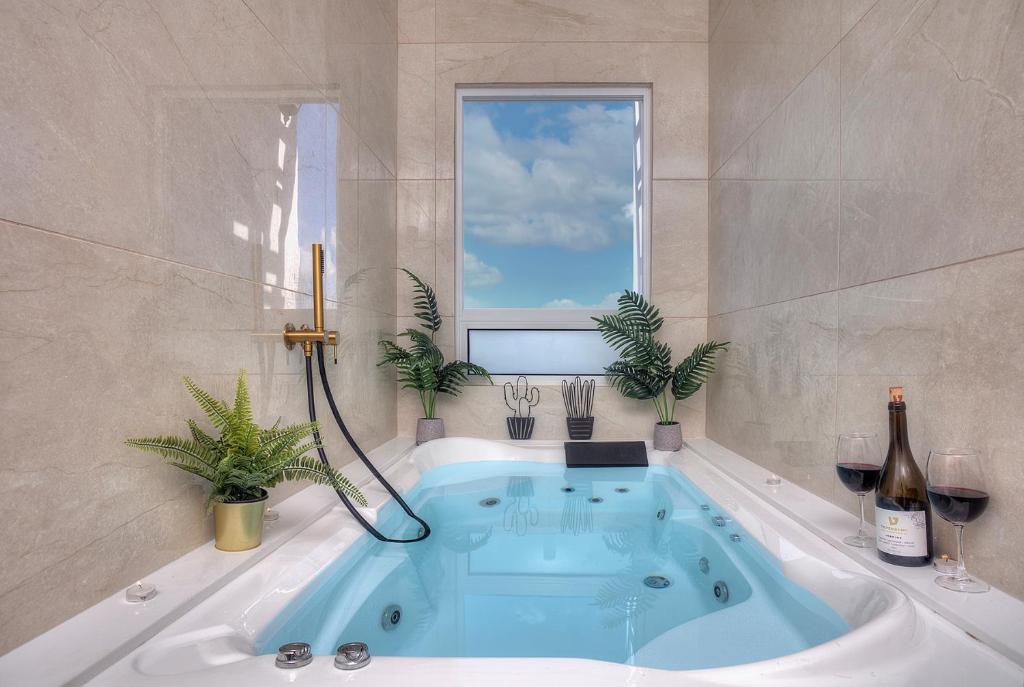 Un baño con bañera y ventana. en Mountain Top Views -204- נופי פסגות, en Safed