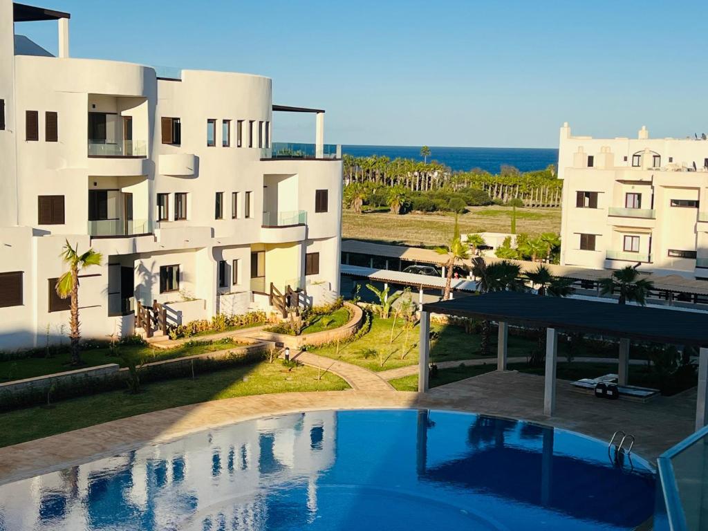 a swimming pool in front of a building at Colina Smir par Immo Marina Vacances de Rêve B1-10 in Oulad Akkou