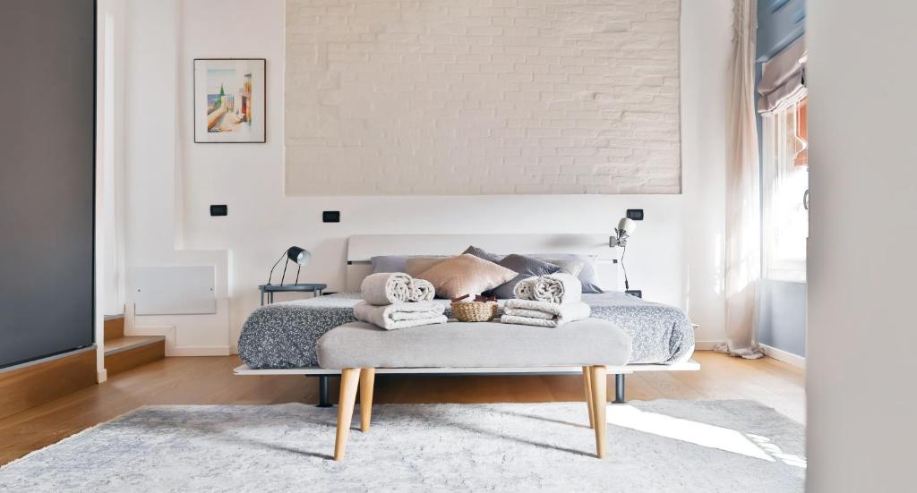 une chambre avec un lit et un mur blanc dans l'établissement The New Place, à Ferrare