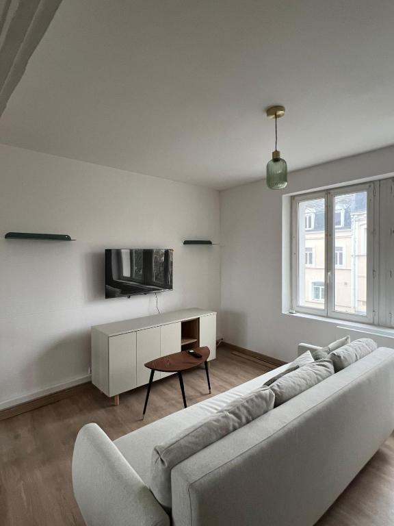 阿拉斯La Coloc'的带沙发和电视的白色客厅