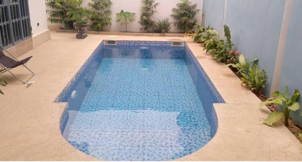 een groot blauw zwembad in het midden van een patio bij Villa - Ngaparou, Sénégal in Ngaparou