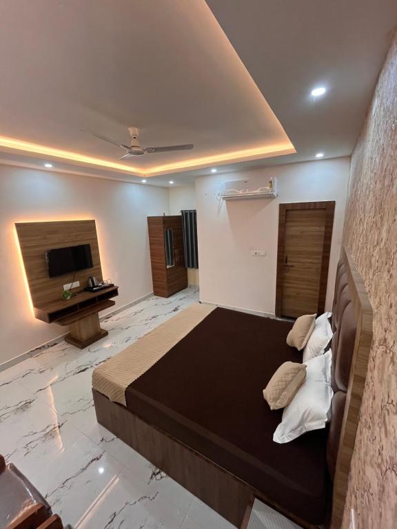 AyodhyaPepper Stayz in Ayodhya near Ramjanmabhoomi的一间带大床和电视的卧室