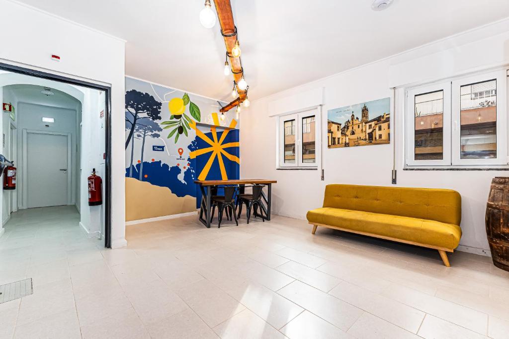 a living room with a yellow couch and a table at Arbutus Bed and Bar in Portimão