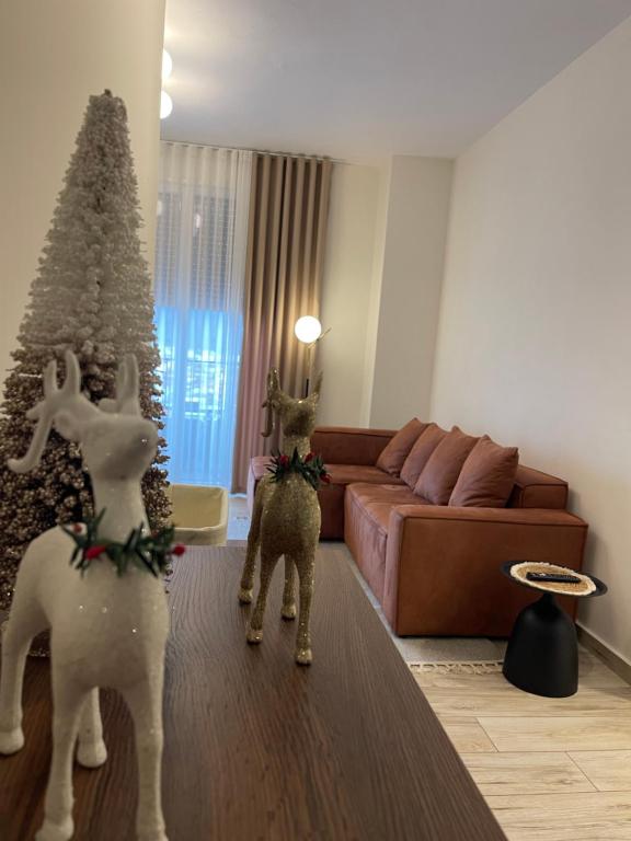 two fake deer in a living room with a christmas tree at Class Elite Apartment in Shkodër