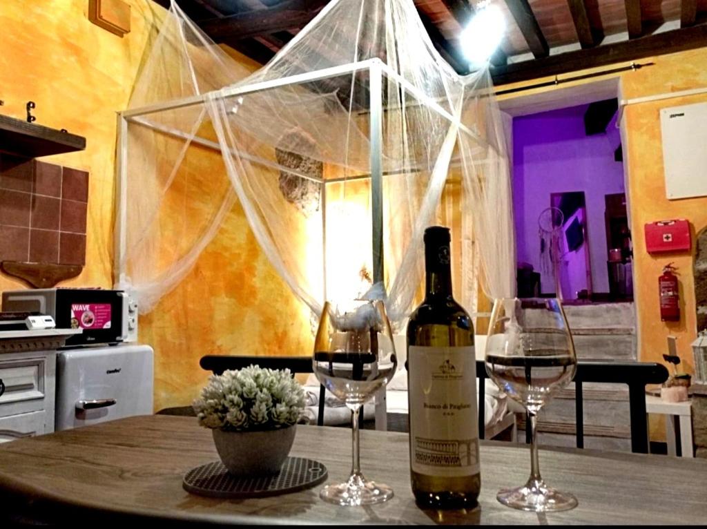 a bottle of wine and two glasses on a table at The secret room in Pitigliano
