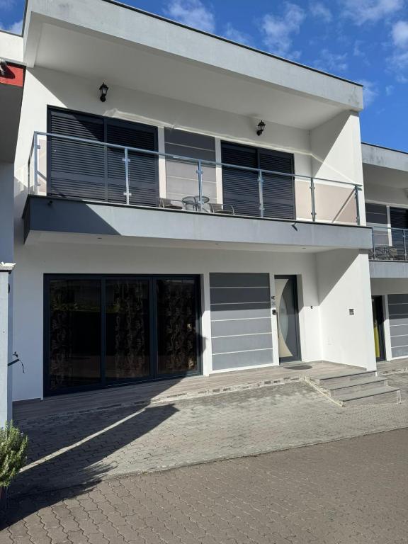 a white house with a balcony on top of it at Elegant Terraced Home with FREE Private Parking in Machico