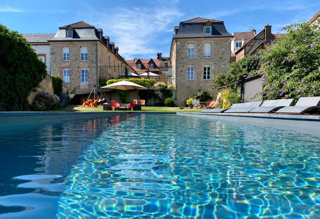einem Wasserpool vor einigen Gebäuden in der Unterkunft Maison d'hôtes La Chevalée in Hautvillers