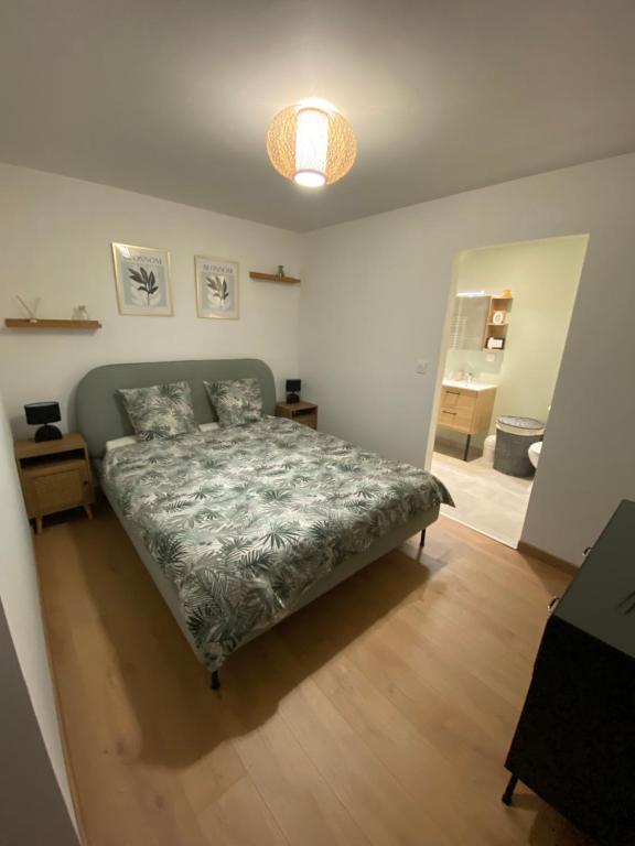 une chambre avec un lit avec une couette verte dans l'établissement COSY Dépendance proche Saint- Émilion, à Le Fieu