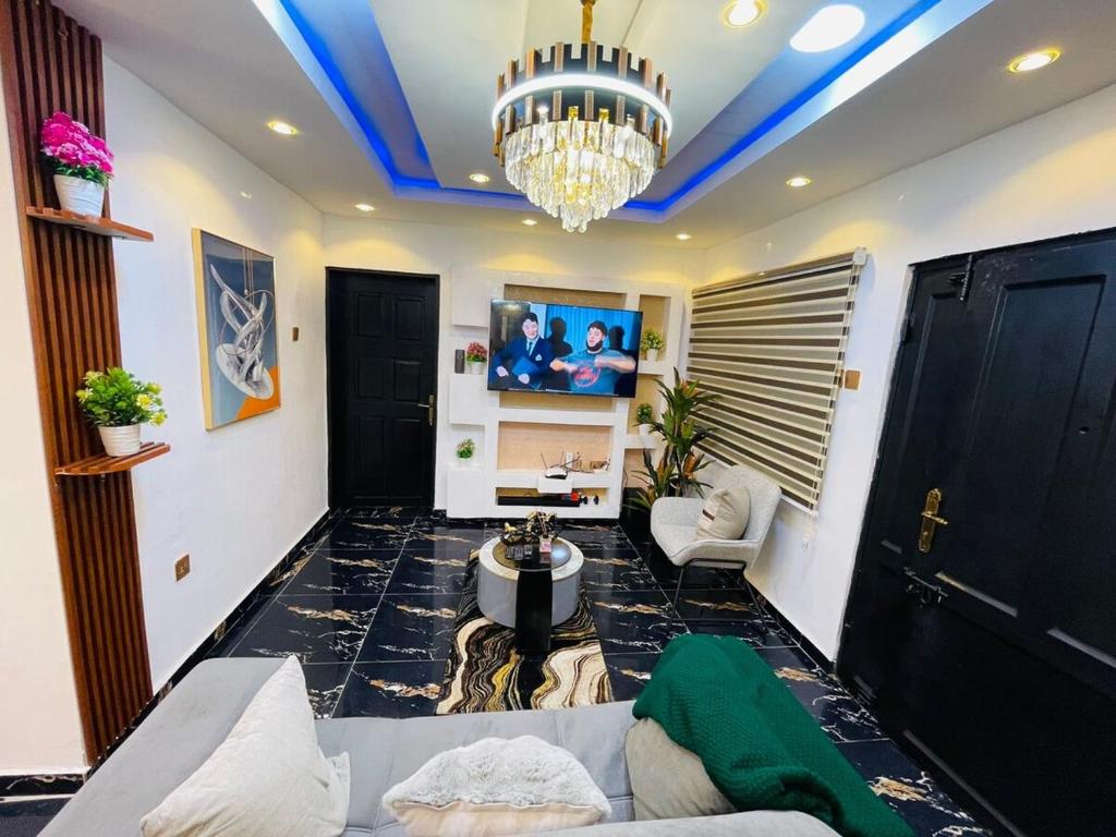 Una sala de estar con un sofá y una lámpara de araña. en DreamBay Homes, en Isheri-Olofin
