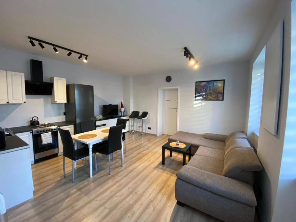 a living room and kitchen with a couch and a table at MIESZKANIE APRTEMNT DO WYNAJECIA na doby Bolesławiec in Bolesławiec
