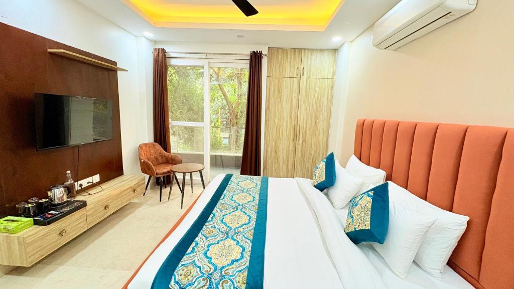 a hotel room with a bed and a television at The Nuvon Residency CR Park in New Delhi