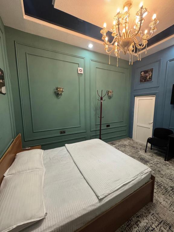 a bedroom with a large bed with a chandelier at Abubakir Guests House in Samarkand