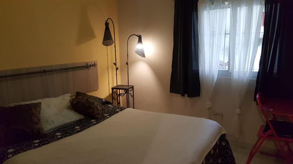 a bedroom with a white bed and a window at Casa cómoda familiar in La Plata