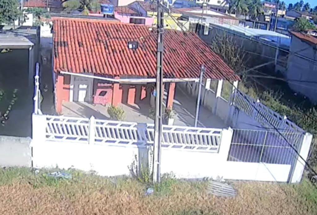 une maison avec une clôture blanche et un toit rouge dans l'établissement Casa de Praia em praia azul pb, à Pitimbu