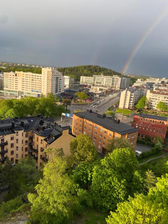 a rainbow over a city with buildings and trees at Wesfield Private in Solna