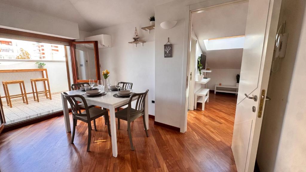 a dining room with a white table and chairs at Gioia's House in Montesilvano