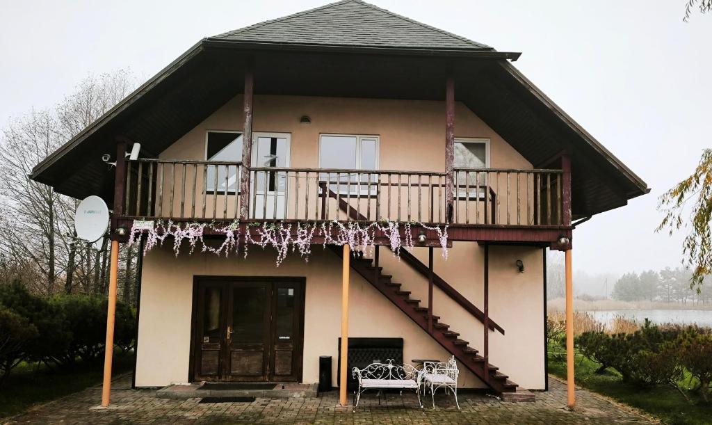 a house with a balcony and a deck at Jaunrūtiņas dīķis in Salaspils